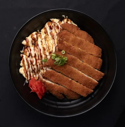 Chicken katsu donburi topped with sliced crumbed chicken.