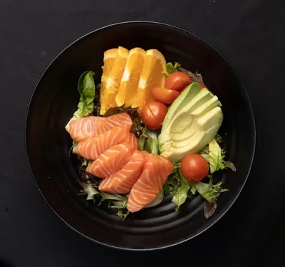Fresh salmon salad with avocado, orange and tomato.