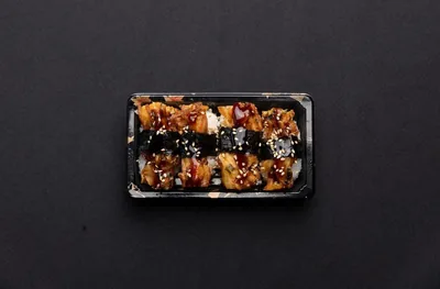 A box of vegetable tempura nigiri sushi.