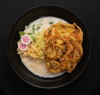 Vegetable tempura ramen in a creamy broth.