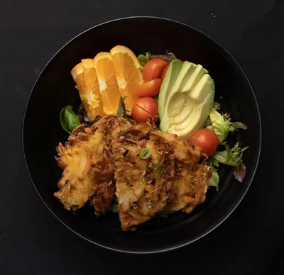 Vegetable tempura salad with avocado and orange.